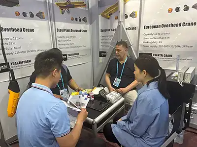 Face-to-face technical consultation at the Yuantai Cranes Canton Fair booth, providing customized crane solutions for steel, manufacturing, logistics, and energy industries.