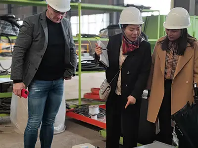 Spanish visitors reviewing customized overhead crane solutions in Yuantai factory