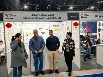 European customers inspecting Yuantai low headroom hoist and compact lifting equipment at Poland exhibition