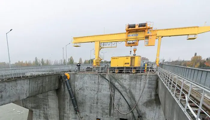 Intake gantry crane for lifting stop logs, trash racks and bulkheads at hydropower water intake structures